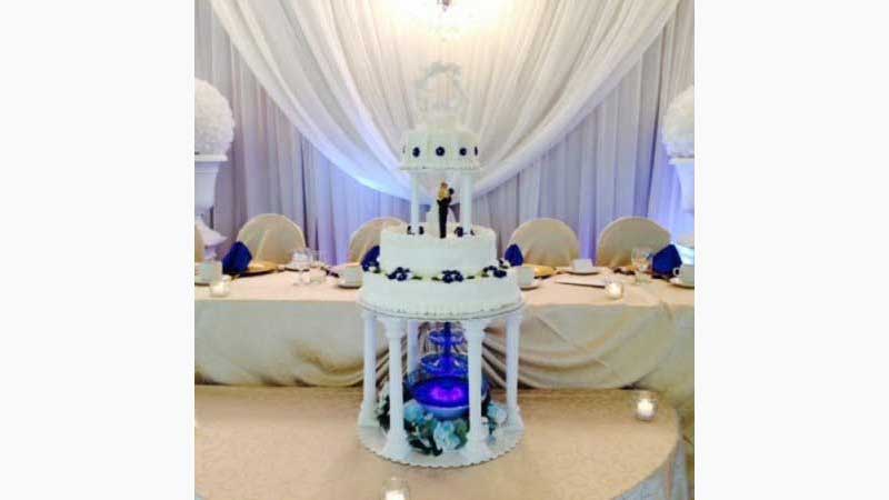 Wedding Cake, DJ Oakville, Beautiful three tier wedding cake, with a 3 tier mauve fountain on the bottom. Water is flowing through all 3 levels of the fountain and it is lit from below. Taken in Oakville Ontario